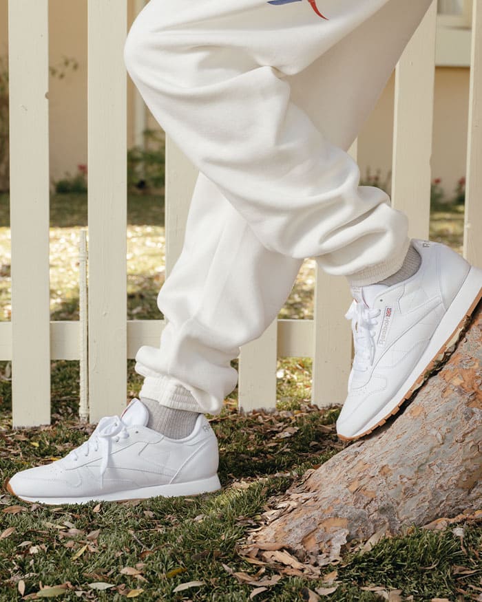 Personne qui s'entraîne avec un legging et des chaussures de course reebok